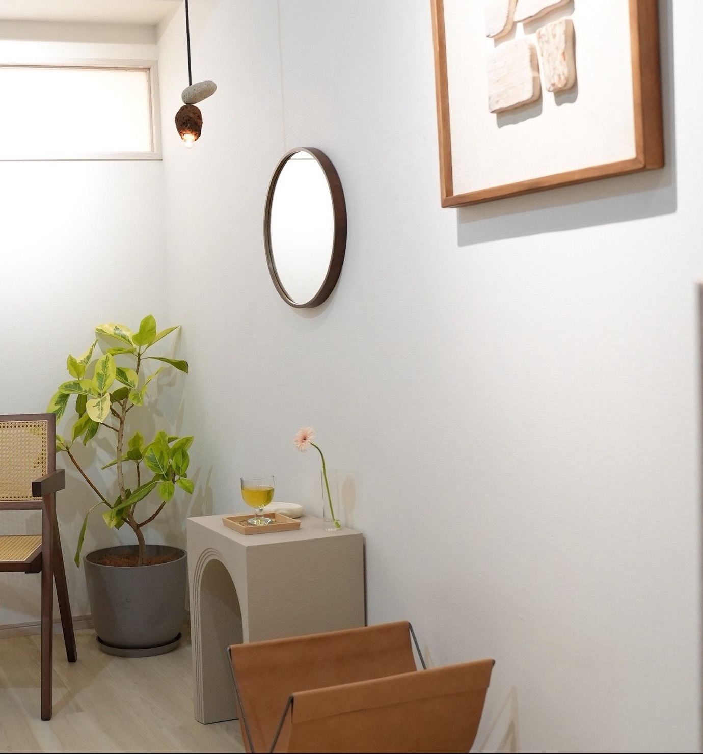 明るく落ち着いたAluの店内。チェアと観葉植物、丸い鏡のある空間